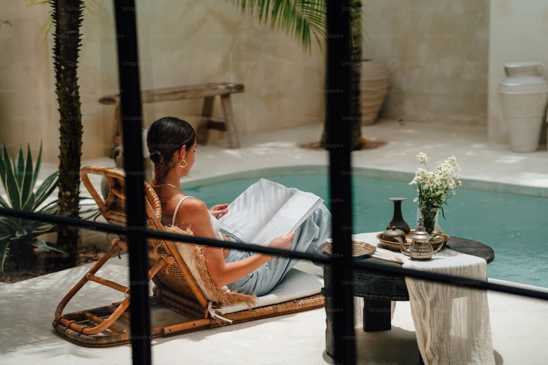 Woman reading by the pool of a spa, riad atmosphere