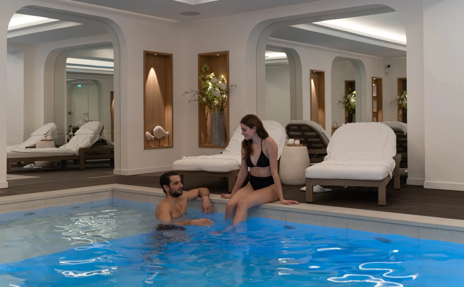 Couple au bord de la piscine intérieure d’un spa