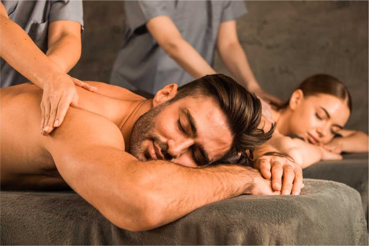 Couple recevant un massage en duo par deux praticiens