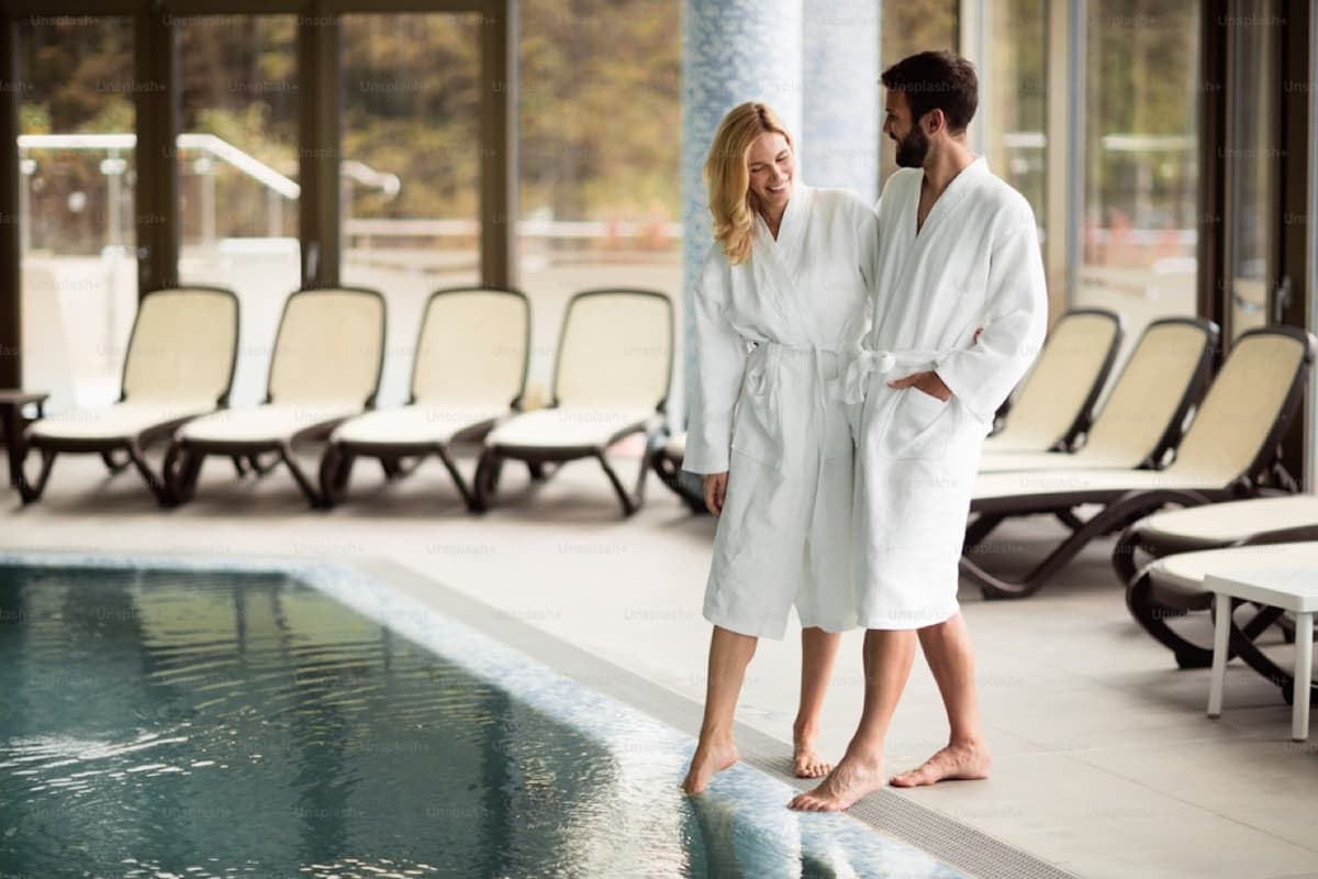 Couple in bathrobes by the pool of a privately booked spa